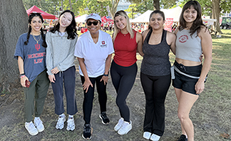 six people stand together under a tree