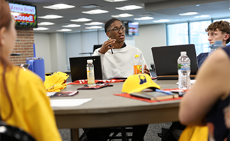 students seated at a round table discussing something