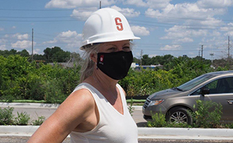 Professor Cynthia Baker wearing a mask and a hard hat