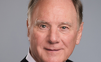 man sitting in front of a portrait photo background
