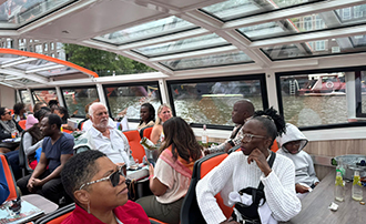 people listening to a tour guide while on a canal boat
