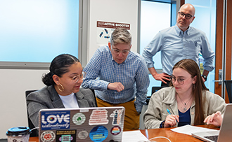 law professors working with law students in a classroom