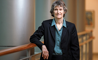 woman standing along a stair landing with her arm resting on a rail