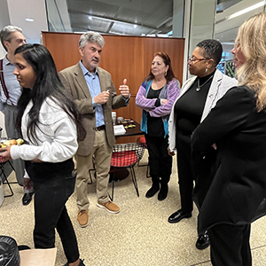 Justice David talking to Dean Bravo and others gathered in the cafeteria
