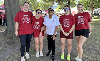 five people stand together under a tree