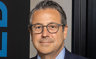 man standing in front of a photo backdrop at an awards cereomony