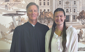 two people standing in front of a mural in a county courthouse