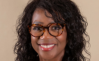 woman seated in front of a photo backdrop