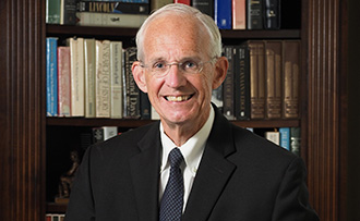 man standing in front of a book shelf