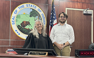 a judge and a law student stand in a courtroom